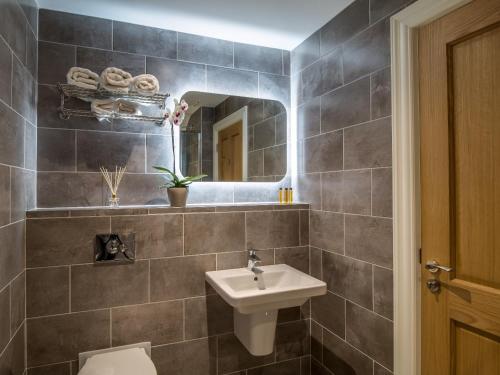 a bathroom with a sink and a toilet and a mirror at Kingston's Townhouse in Killorglin