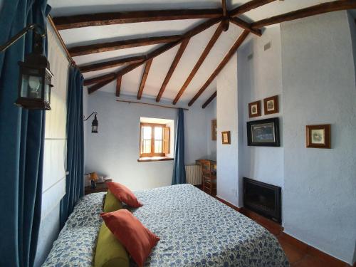a bedroom with a bed with a blue comforter at Molino de Las Pilas - Ecoturismo - Caminito del Rey in Teba