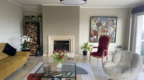 a living room with a couch and chairs and a fireplace at Brest and Breakfast vue mer in Brest