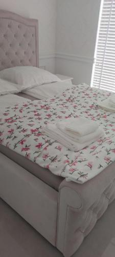 a bed with a white bedspread with flowers on it at PARAISO GLAMOUR 10B in Łukęcin