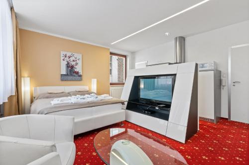 a bedroom with a bed and a flat screen tv at Vila Jiřinka in Luhačovice