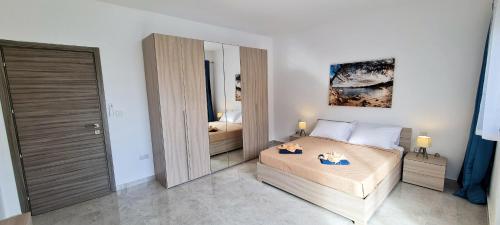 een slaapkamer met een bed en een grote spiegel bij Seaside Serenity 8 - few mins walk to the beach in Mellieħa
