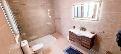 een badkamer met een wastafel, een toilet en een douche bij Seaside Serenity 8 - few mins walk to the beach in Mellieħa
