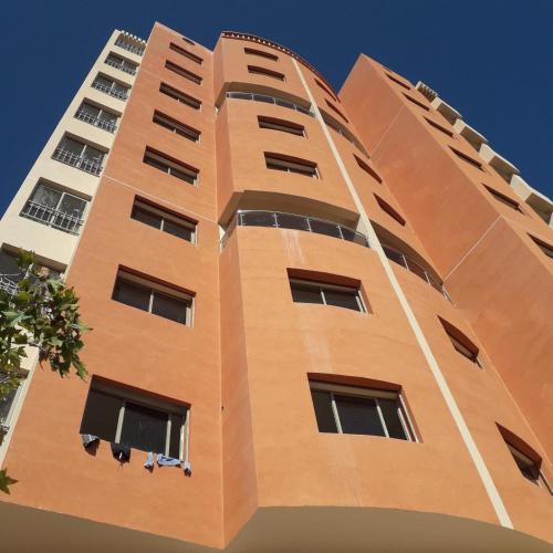 um edifício laranja alto com janelas em ديار المنصور بني ملال المغرب em Beni Mellal