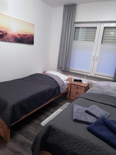 a bedroom with two beds and a window at Allee zum See in Schüttorf