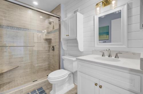 a bathroom with a toilet and a sink and a shower at 204 B Port O Call by AvantStay Beachfront Condo in Isle of Palms