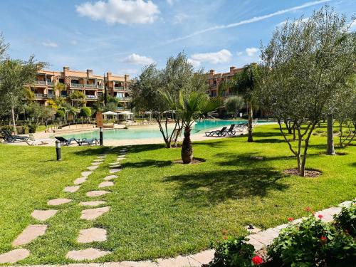 un complexe avec une piscine et des arbres dans un parc dans l'établissement Stunning Apartment - Panoramic pool view, à Marrakech
