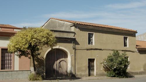an old building with an archway and a garage at Funtana Meiga, il tuo angolo di paradiso in Funtana Meiga