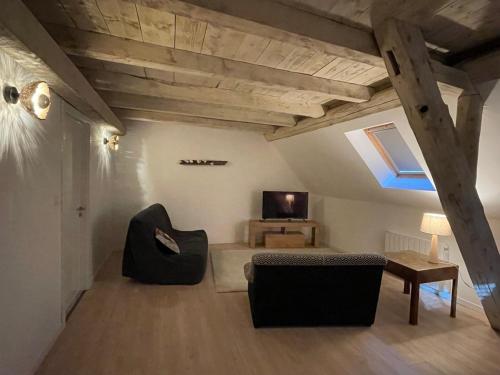 a living room with a couch and a table and a television at La grange de Sophie in Berstett