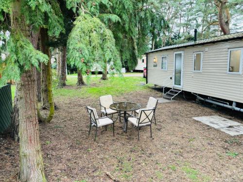 a patio with a table and chairs and a trailer at WILD DUCK HAVEN RESORT in Belton