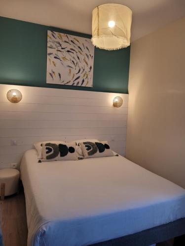 a bedroom with a bed with two pillows on it at Hôtel Le Rivage vue sur mer - Châtelaillon-plage in Châtelaillon-Plage