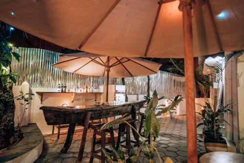a restaurant with a table and two large umbrellas at Pili Pili Kahawa House in Stone Town