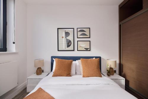 a bedroom with a blue and white bed with pillows at The Harlesden Place - Modern 3BDR Flat with Balcony in London