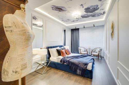 a bedroom with a blue bed and a table and chairs at Apartamenty Tespis - Francuska Atal Park PREMIUM in Katowice