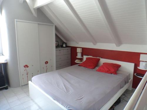 - une chambre avec un lit blanc et des oreillers rouges dans l'établissement villa bougainvillier jardin privatif, à Saint-François