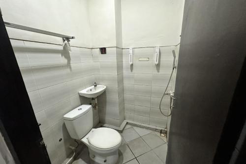 La salle de bains est pourvue de toilettes et d'un lavabo. dans l'établissement Hotel Warta Dua, à Denpasar