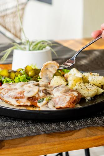 a person eating a plate of food with a fork at Hotel Piedras De Maní in Manizales