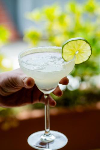 a hand holding a margarita with a lime slice in it at Hotel Piedras De Maní in Manizales
