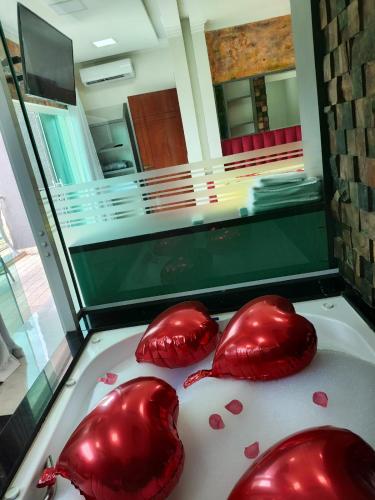 two red hearts are on the floor of a room at Pousada Mirante do César in Bombinhas