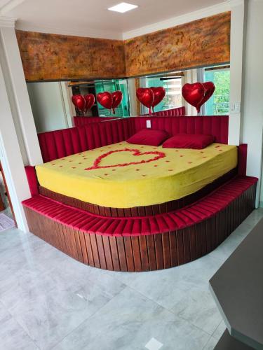 a bedroom with a bed with red hearts on it at Pousada Mirante do César in Bombinhas