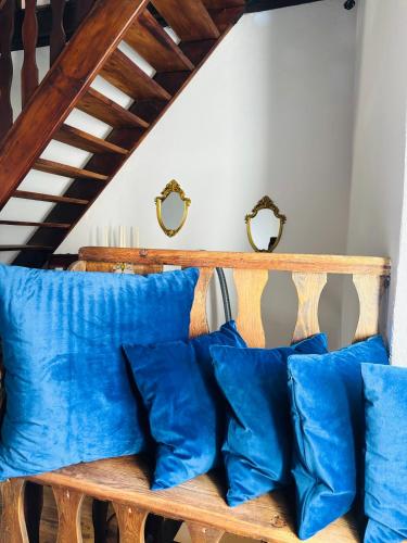 a wooden bench with blue pillows on it at FOPPOLI CASTLE, PRIVATE 11th CENTURY FORTRESS WITH PANORAMIC VIEW, SAUNA AND HOT TUB OVERLOOKING THE VALTELLINA in Mazzo di Valtellina