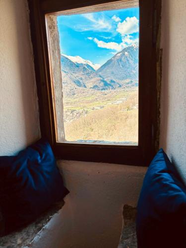 a window with a view of a mountain view at FOPPOLI CASTLE, PRIVATE 11th CENTURY FORTRESS WITH PANORAMIC VIEW, SAUNA AND HOT TUB OVERLOOKING THE VALTELLINA in Mazzo di Valtellina