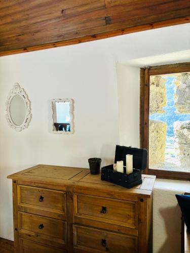 a room with a wooden dresser and a window at FOPPOLI CASTLE, PRIVATE 11th CENTURY FORTRESS WITH PANORAMIC VIEW, SAUNA AND HOT TUB OVERLOOKING THE VALTELLINA in Mazzo di Valtellina
