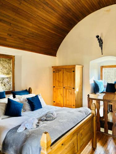 a bedroom with a large bed with blue pillows at FOPPOLI CASTLE, PRIVATE 11th CENTURY FORTRESS WITH PANORAMIC VIEW, SAUNA AND HOT TUB OVERLOOKING THE VALTELLINA in Mazzo di Valtellina