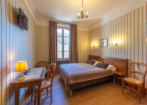 1 dormitorio con 1 cama, mesa y sillas en Hotel De La Cloche, en Beaune