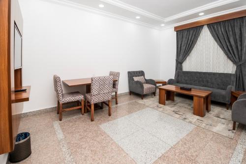 a living room with a couch and a table and chairs at فندق انوار - Anwar Hotel in Al Madinah