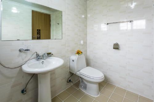 uma casa de banho com um WC, um lavatório e um espelho. em Jeju Wayo Pension em Jeju