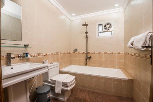 a bathroom with a tub and a toilet and a sink at انوار احد in Al Madinah