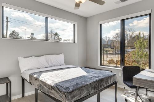 ein Schlafzimmer mit einem Bett und zwei Fenstern in der Unterkunft Charming Apartment - 4 Mi to IU Memorial Stadium! in Bloomington