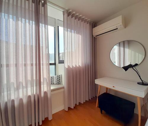 um quarto com uma secretária, um espelho e uma janela em Porto Soul by Flat in Porto no Porto