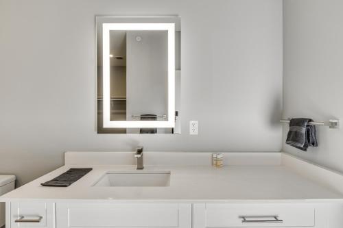 ein weißes Badezimmer mit einem Waschbecken und einem Spiegel in der Unterkunft Charming Apartment - 4 Mi to IU Memorial Stadium! in Bloomington