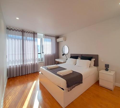 um quarto com uma grande cama branca e um espelho em Porto Soul by Flat in Porto no Porto