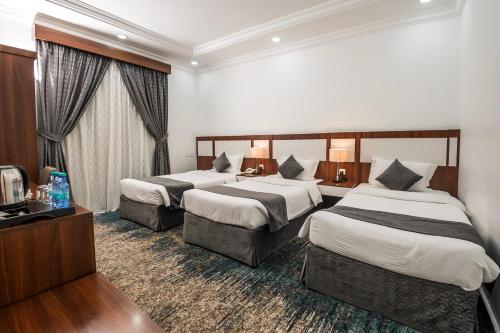 a hotel room with two beds and a television at انوار احد in Al Madinah