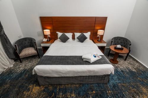 a hotel room with a bed and two chairs at فندق انوار - Anwar Hotel in Al Madinah