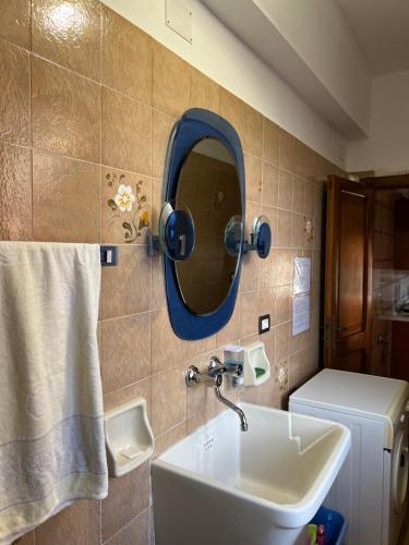 łazienka z umywalką i lustrem na ścianie w obiekcie LA ROSA DEI VENTI w mieście Villafranca Tirrena