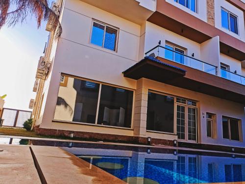 a building with a swimming pool in front of it at Royal Elegance Room in Sheikh Zayed