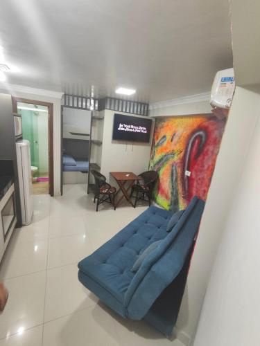 a living room with a blue couch and a painting at Pousada Mirante do César in Bombinhas