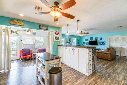 a living room with blue walls and a ceiling fan at Dock and Bay Access Rockport Home on Canal in Rockport