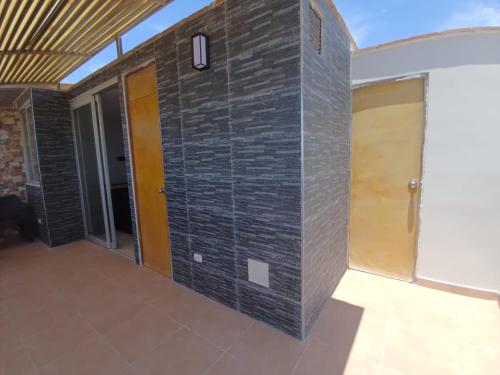 a room with a brick wall with two doors at Apartamento duplex, con terraza y vista de Chiclayo in Chiclayo