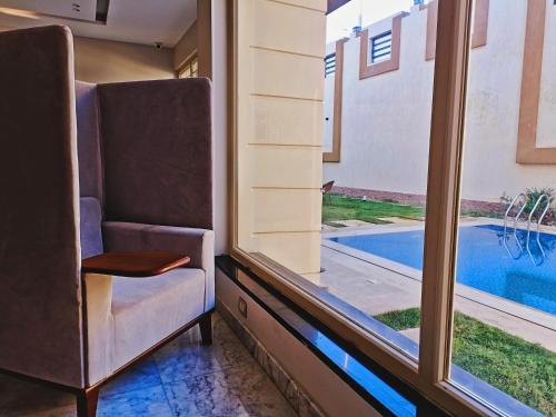 a room with a window with a view of a swimming pool at Grand Room in Sheikh Zayed