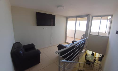 a living room with couches and a flat screen tv at Apartamento duplex, con terraza y vista de Chiclayo in Chiclayo