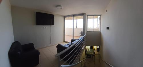 a living room with a couch and a television at Apartamento duplex, con terraza y vista de Chiclayo in Chiclayo