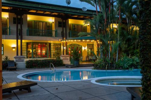 a hotel with a swimming pool in front of a building at Hotel Casa Turire in Turrialba