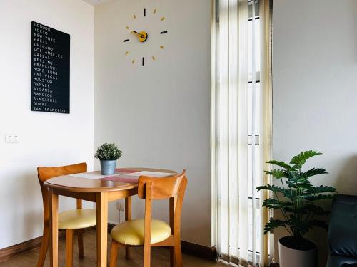 a table and two chairs and a clock on a wall at Cozy Victoria Lakeview 5 mins to Impact Muang Thong in Ban Bang Phang