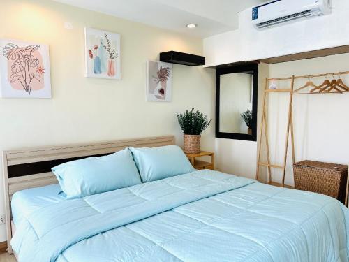 - une chambre avec un lit et une couette bleue dans l'établissement Cozy Victoria Lakeview 5 mins to Impact Muang Thong, à Ban Bang Phang