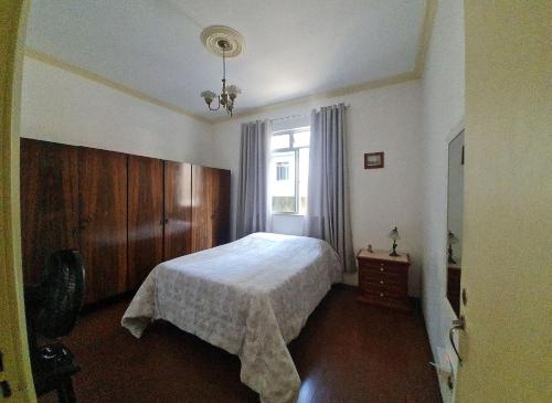 a bedroom with a bed and a window at Apartamento no Centro Parq Halfeld Juiz fora in Juiz de Fora